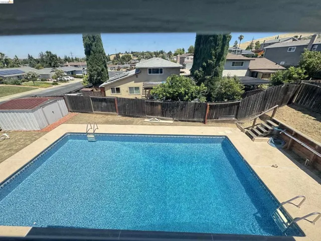 Rectangular in-ground pool featuring a blue mosaic-patterned liner and integrated steps