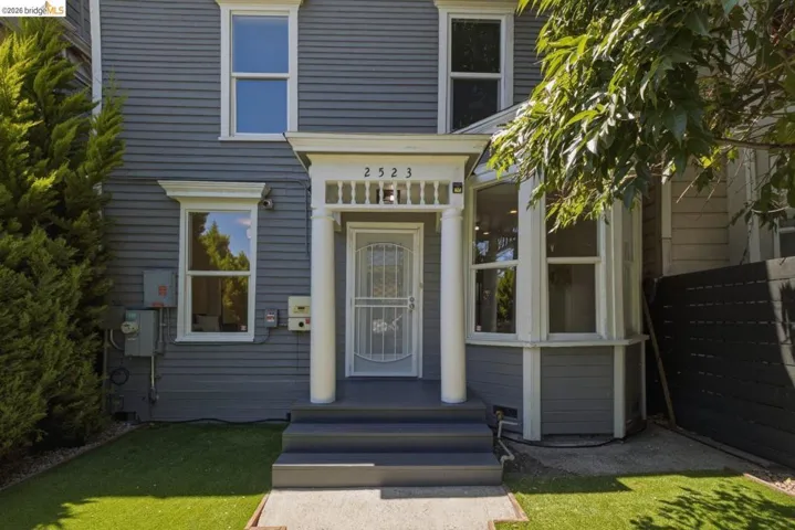 Gray clapboard siding with white trim accents and a prominent bay window