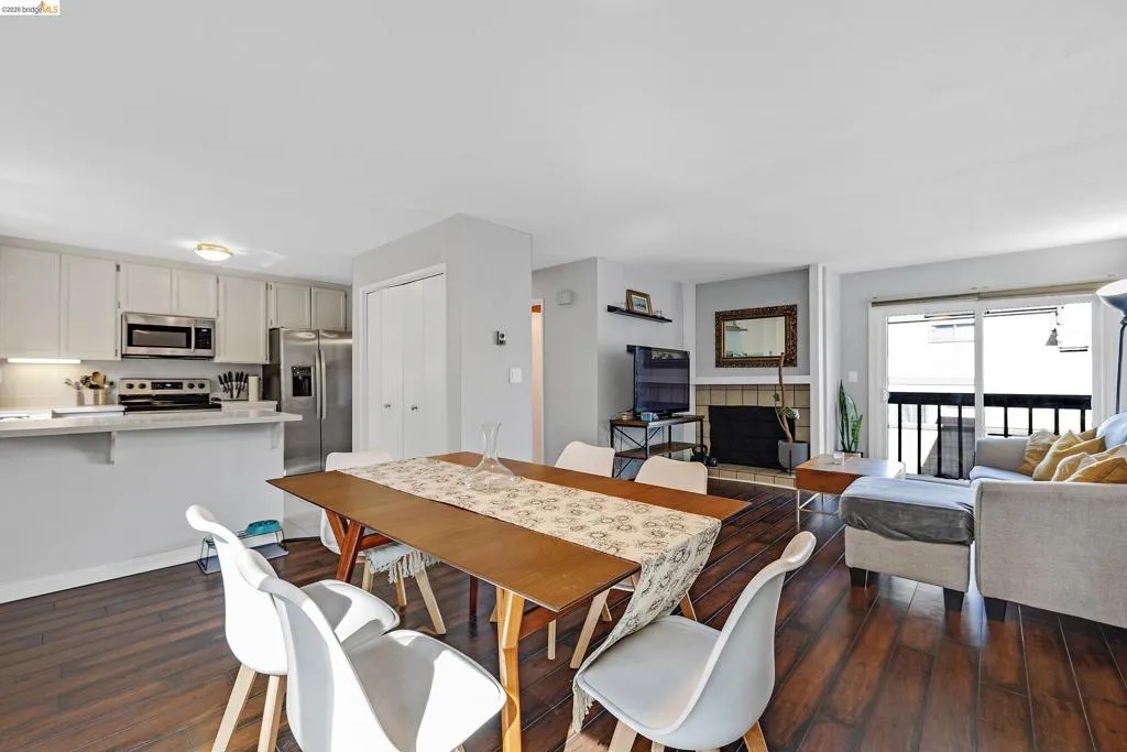 Dining space with dark wood-style floors and a tile fireplace