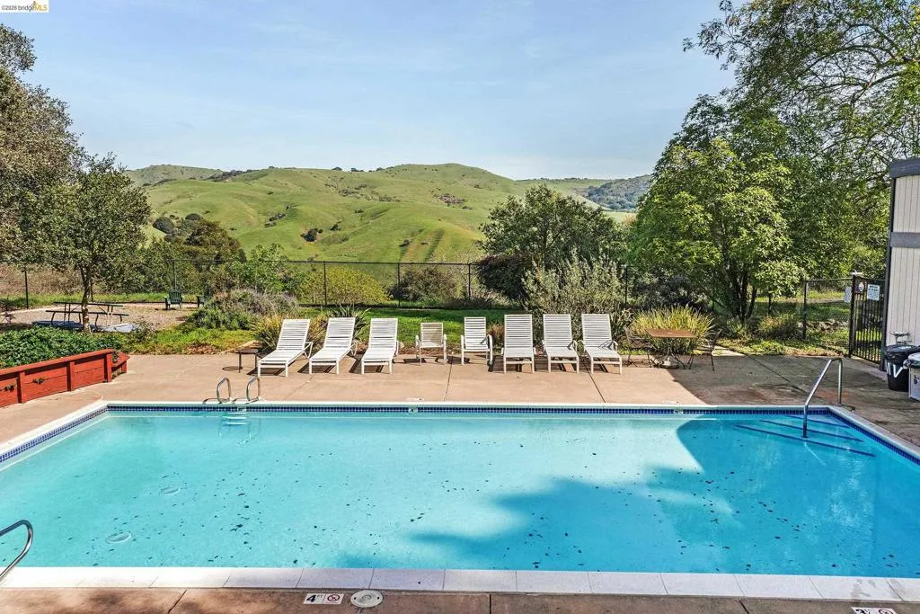Community pool featuring a mountain view and a patio area