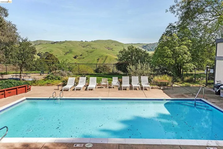 Community pool featuring a mountain view and a patio area