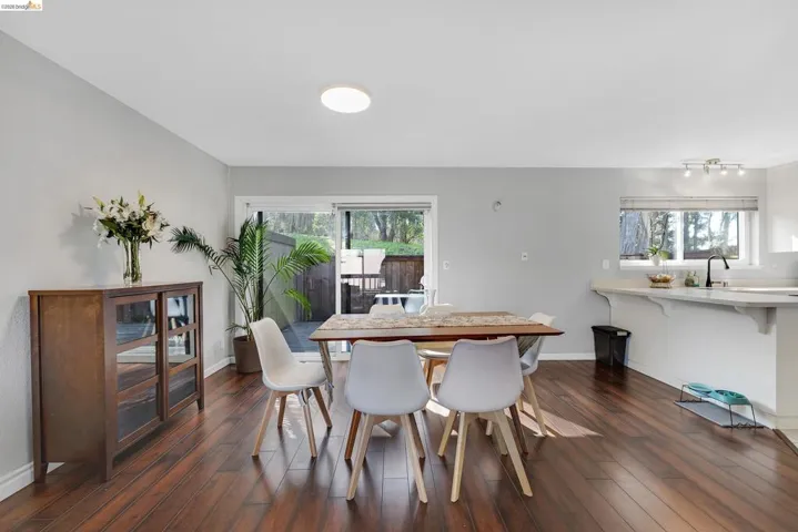 Dining space featuring baseboards and dark wood-style flooring