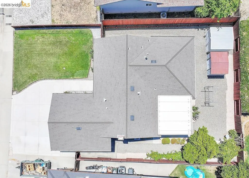 Aerial view showcasing a residential property with a gray shingled roof