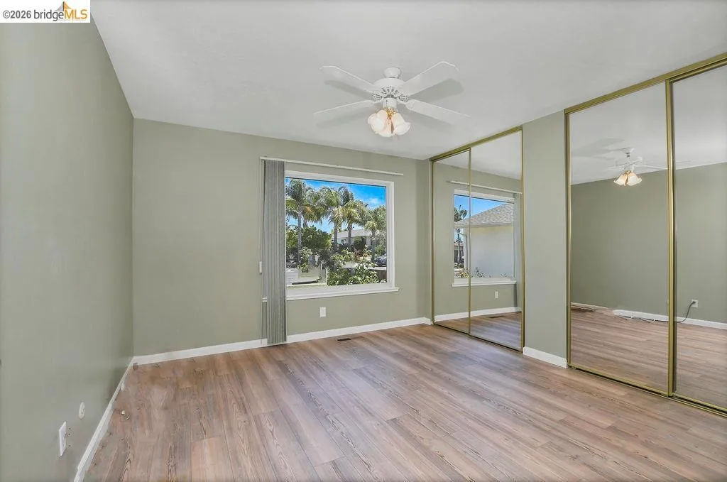 Spacious room featuring wood-finish flooring and a light green wall color