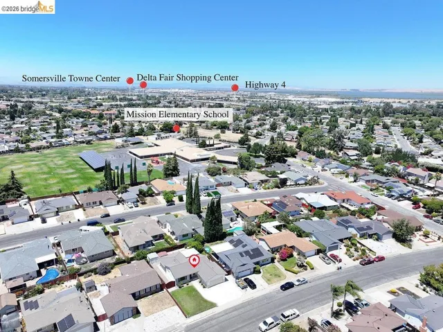 Aerial perspective of a residential community featuring single-family homes with diverse rooflines and landscaping