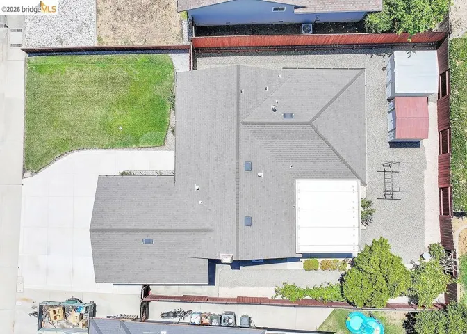 Aerial view showcasing a residential property with a gray shingled roof