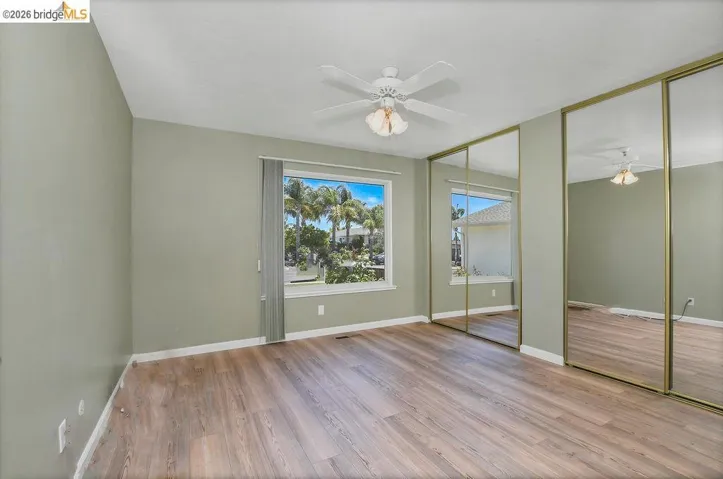 Spacious room featuring wood-finish flooring and a light green wall color