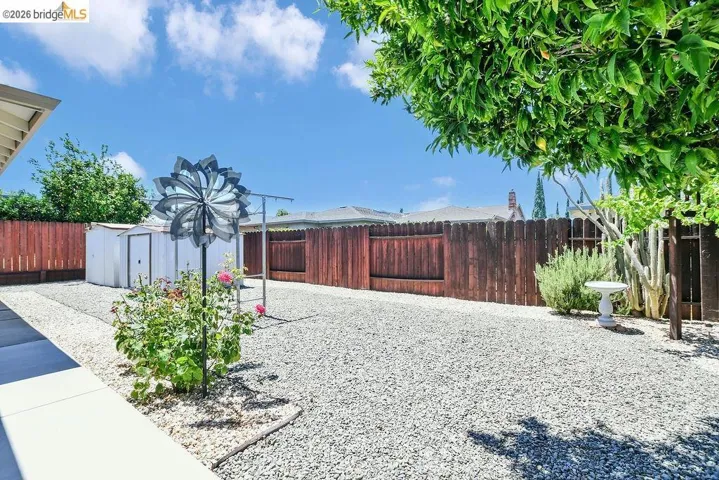 Spacious backyard featuring extensive gravel hardscaping and perimeter fencing