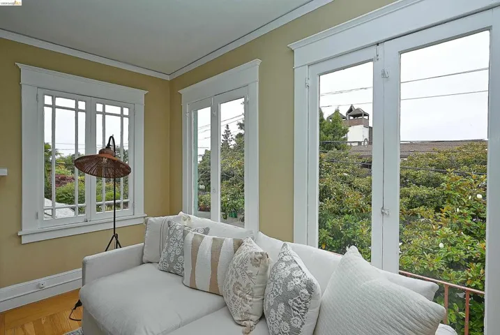 Light-filled interior featuring multiple windows with white trim, crown molding, and hardwood floors.