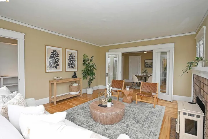 Hardwood flooring complements a decorative fireplace with a brick surround and white mantel