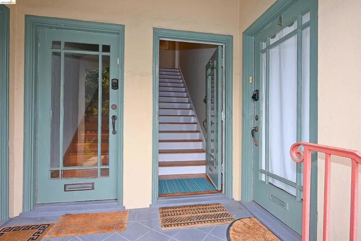 Entryway featuring three paneled doors with glass inserts, two of which are painted a muted teal