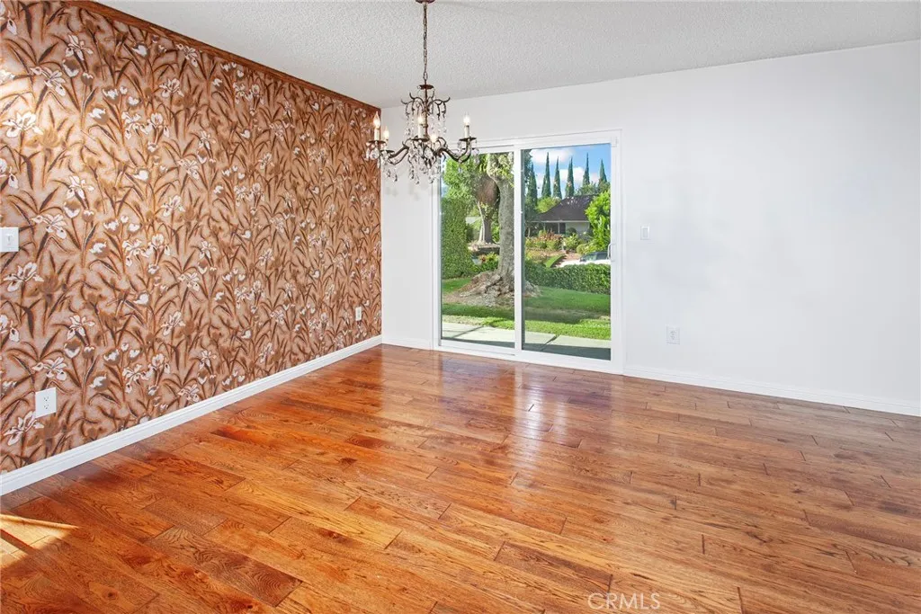 The dining room, filled with natural light from new vinyl sliding glass doors, provides an inviting setting for casual family dinners and holiday celebrations alike.