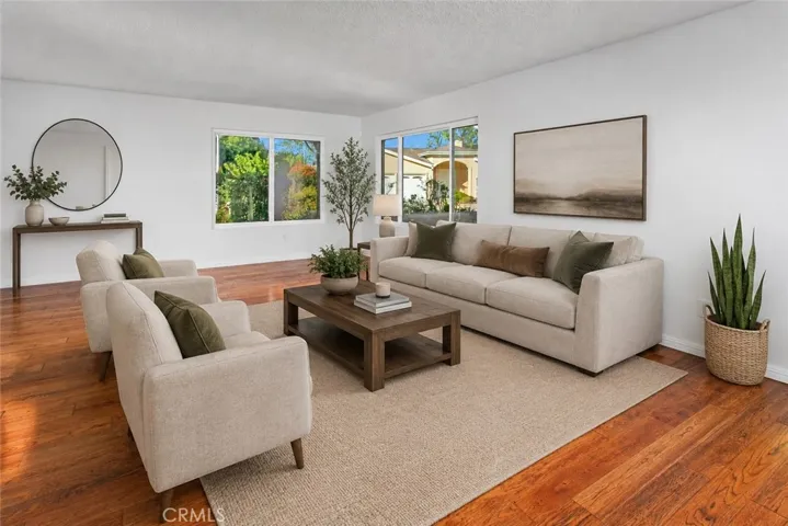 Photo is virtually staged.  Property shows as in previous photo.  The spacious living room is filled with hardwood floors and abundant natural light.