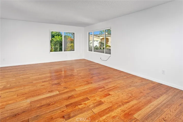 The spacious living room is filled with hardwood floors and abundant natural light.