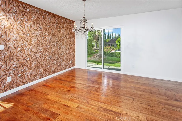 The dining room, filled with natural light from new vinyl sliding glass doors, provides an inviting setting for casual family dinners and holiday celebrations alike.
