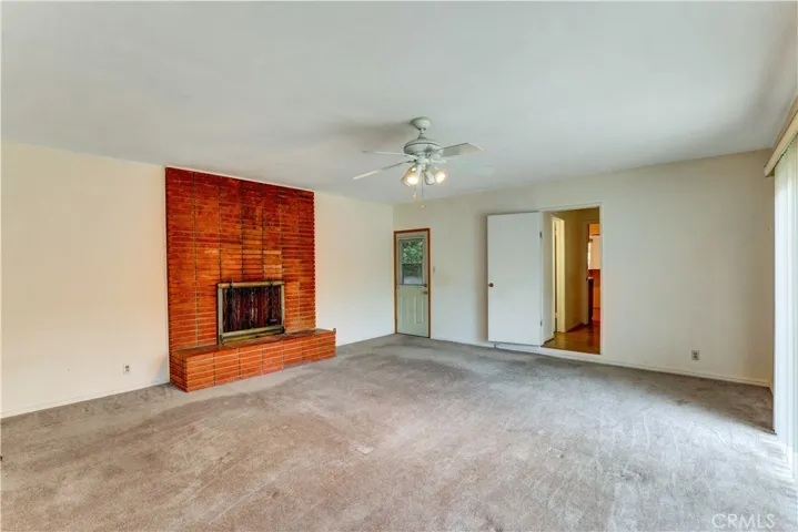 The big family bedroom has three access doors. 1) to the side yard. 2) sliding door to the backyard. 3) to the hallwaay leading to a full bathroom, laundry room, and the kitchen.