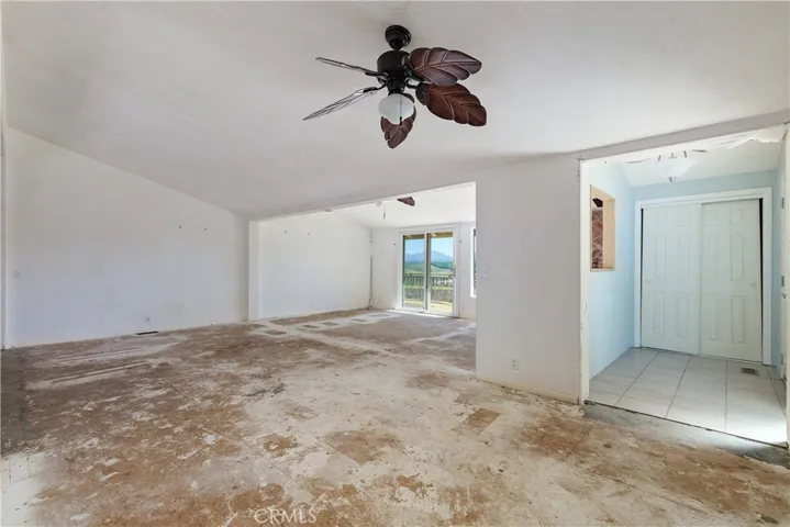 Entry into home with a closet and tile flooring. The oversized great room with 2 ceiling fans. This may also be your dining room/great room combo and the additional area with sliding door to exterior deck.