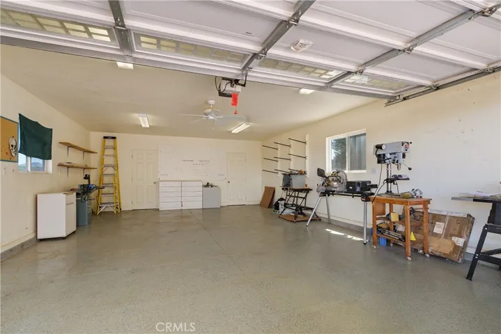 Fully permited Detached Barn/Workshop with epoxy flooring. This area also has a storage closet with built-in shelving and another room with pull down ladder to the game room/loft as additional access. (wood working items shown do not convey/not included) Peg board for tools and white tool drawers stay.