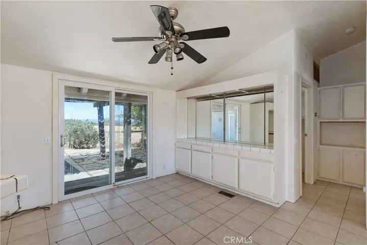 Dining room with cabinetry,tile flooring and access to the back patio area.