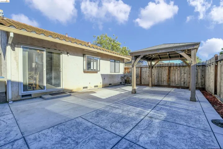 Expansive stamped concrete patio featuring a wood gazebo with a metal roof