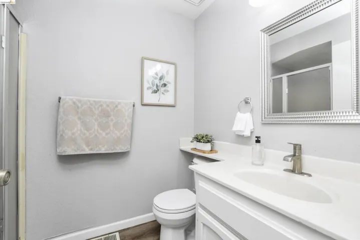 Vanity with integrated sink, brushed nickel faucet, and white cabinetry