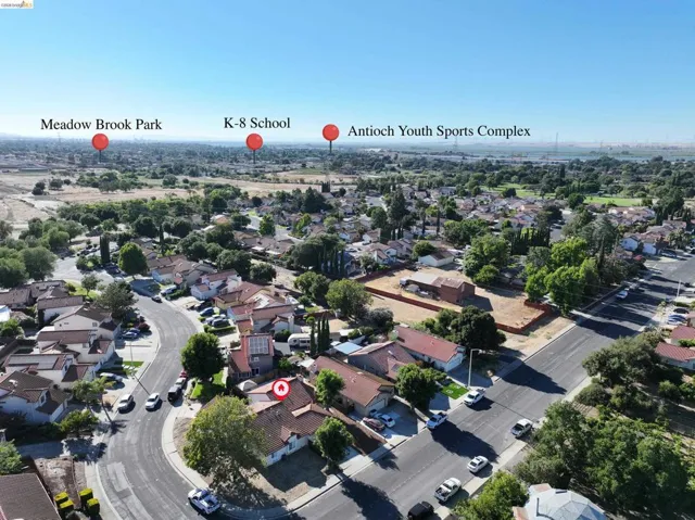 Aerial view showcasing the residential neighborhood with mature trees and established properties