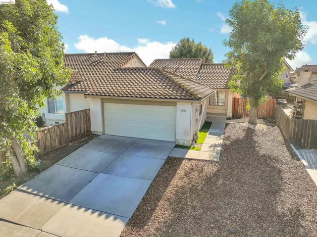 Front exterior featuring a two-car garage, concrete tile roof, and stucco siding