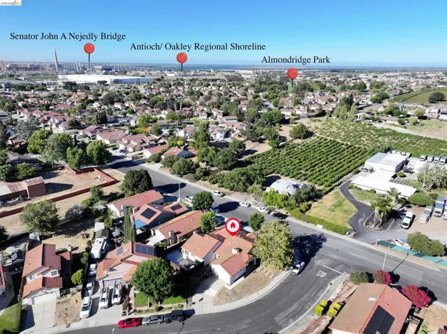 Aerial perspective of a residential neighborhood with a variety of single-story homes featuring red tile roofs