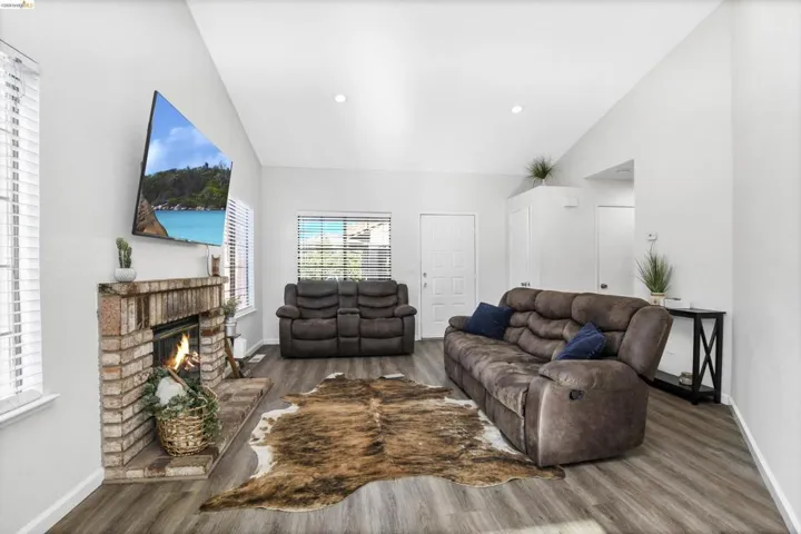 Living area featuring vaulted ceilings and wood-finish flooring