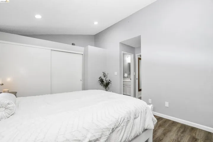 Vaulted ceiling bedroom with wood-finish flooring