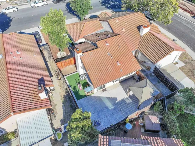 Aerial view showcasing a residential property with terracotta-style tile roofing and a spacious rear patio