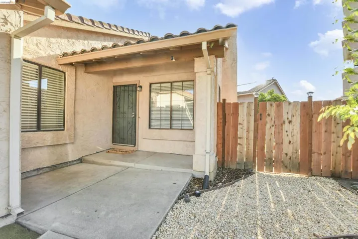 Stucco exterior with a tiled roofline and covered entry