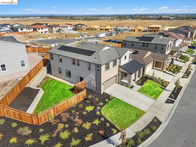 Modern two-story residence with a multi-tone exterior, attached two-car garage, and a solar panel system