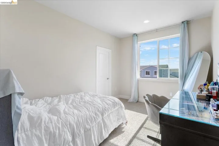 Light-filled room featuring neutral wall paint and plush carpet flooring