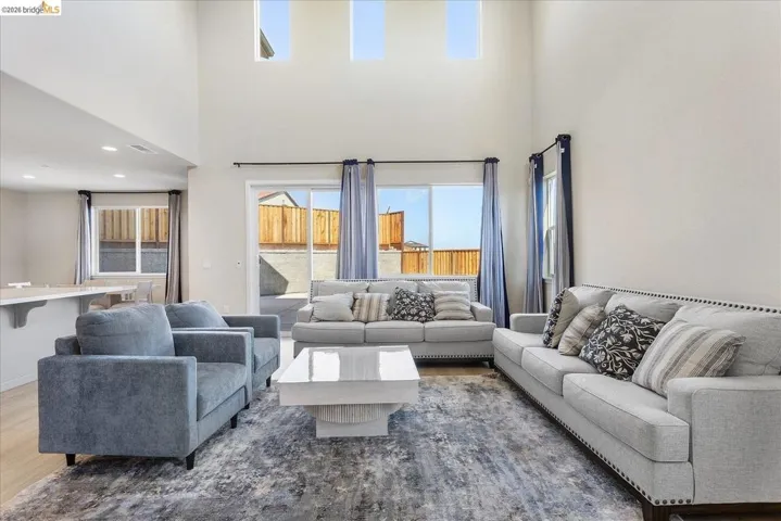 Spacious living area featuring a vaulted ceiling and three high transom windows
