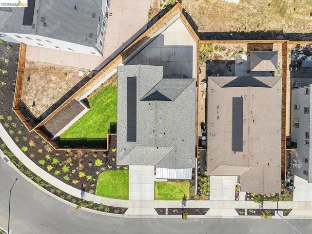 Overhead perspective showcasing the property with a shingled roof and solar panels