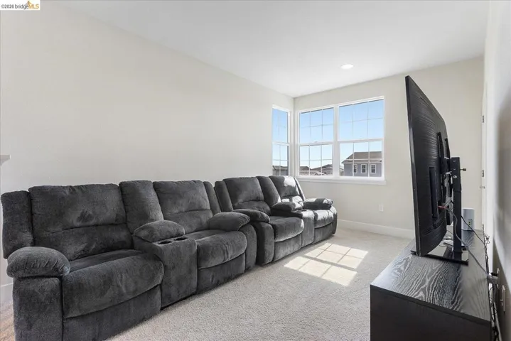 Carpeted room with light-toned walls and multiple windows