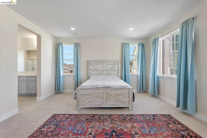 Carpeted room with recessed lighting and multiple windows
