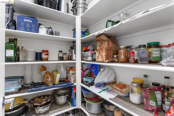 Floor-to-ceiling pantry shelving with white finishes and ample storage capacity