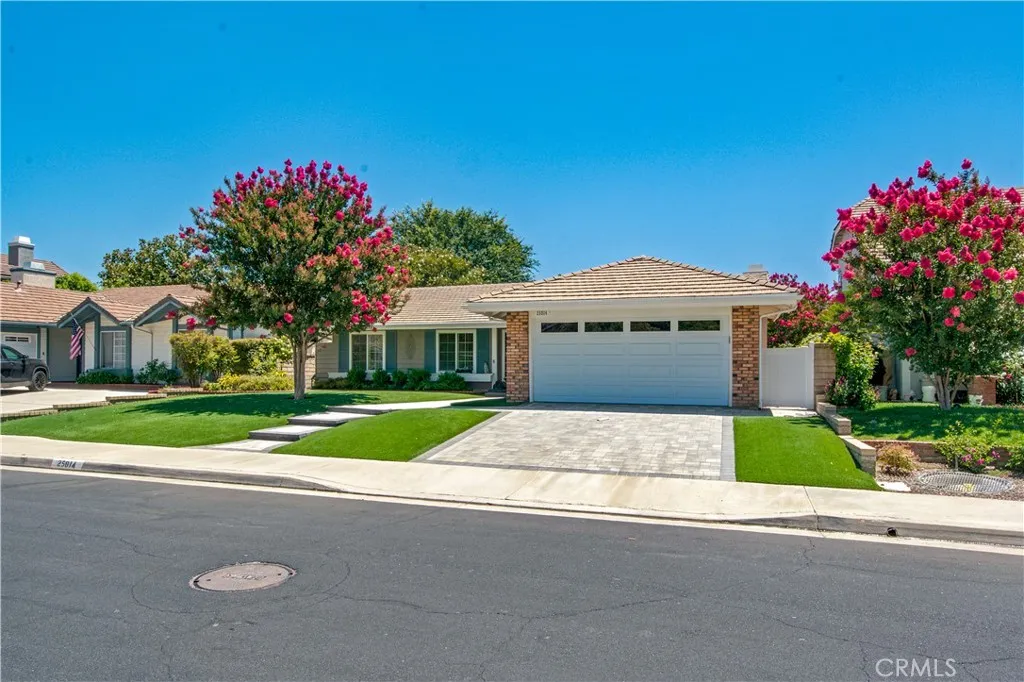 Front of home including interlocking concrete paver driveway.