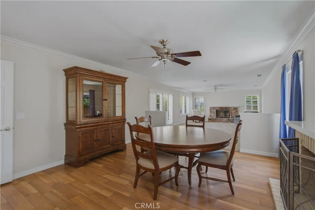 View of dining and family room from kitchen including another fireplace at end of family room.