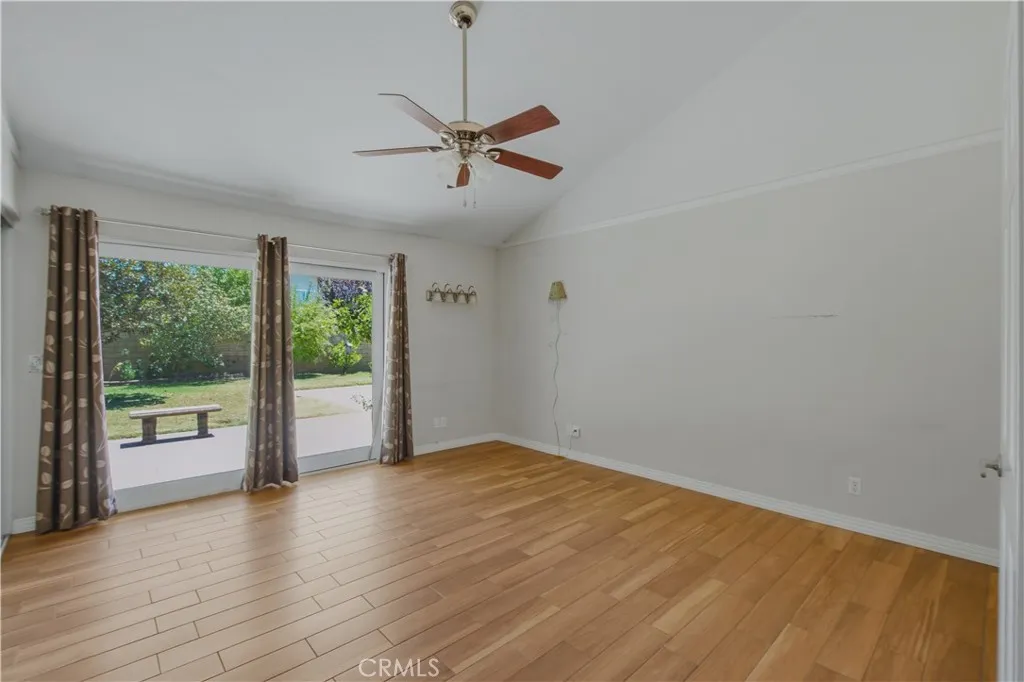 Primary ensuite bedroom including vaulted ceiling, fan with light and dual pane slider to access back yard.