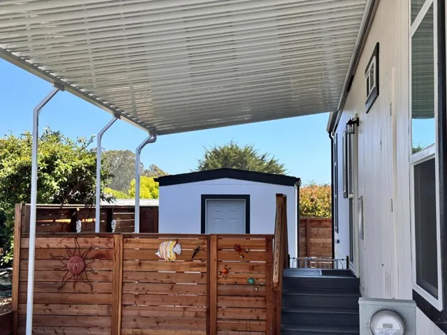 Fashionable fencing that encloses the side yard with a gate to driveway.