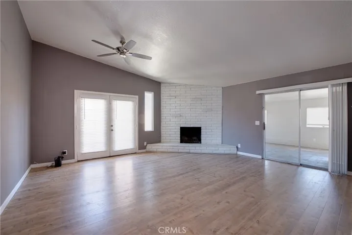 Entering the living room with a charming brick fireplace serves as a warm focal point for gathering with family and friends.