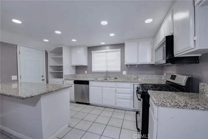 The well appointed kitchen has granite countertops, LED lighting and convenient cabinets with pull out drawers.