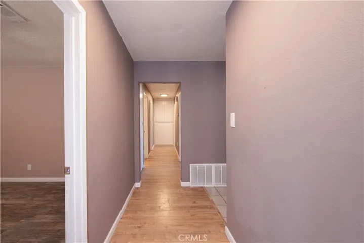 The hallway leads to the four bedrooms and two bathrooms. Notice the ample storage at the side and end of the hallway.