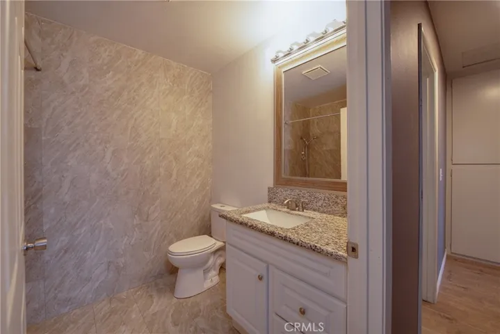 The remodeled hall bathroom is conveniently located featuring a granite countertop and floor to ceiling tile.