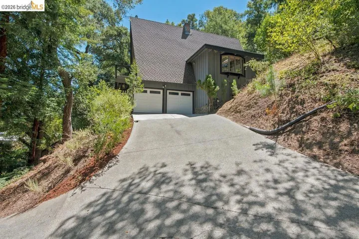 Modern A-frame exterior featuring a two-car garage, a bay window, and a private balcony