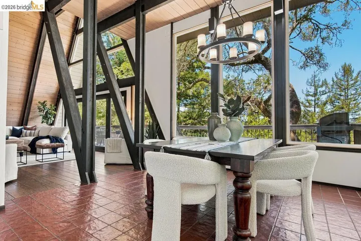Dining area featuring a dark wood table, upholstered chairs, and a round chandelier