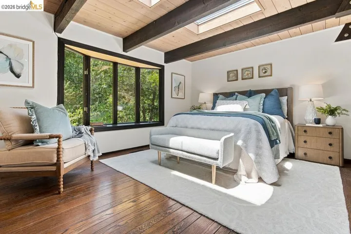 Hardwood flooring complemented by a vaulted wood plank ceiling with exposed beams and skylights
